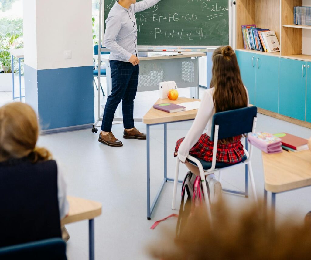 Instructor teaching students in a bright classroom, emphasizing interactive learning.